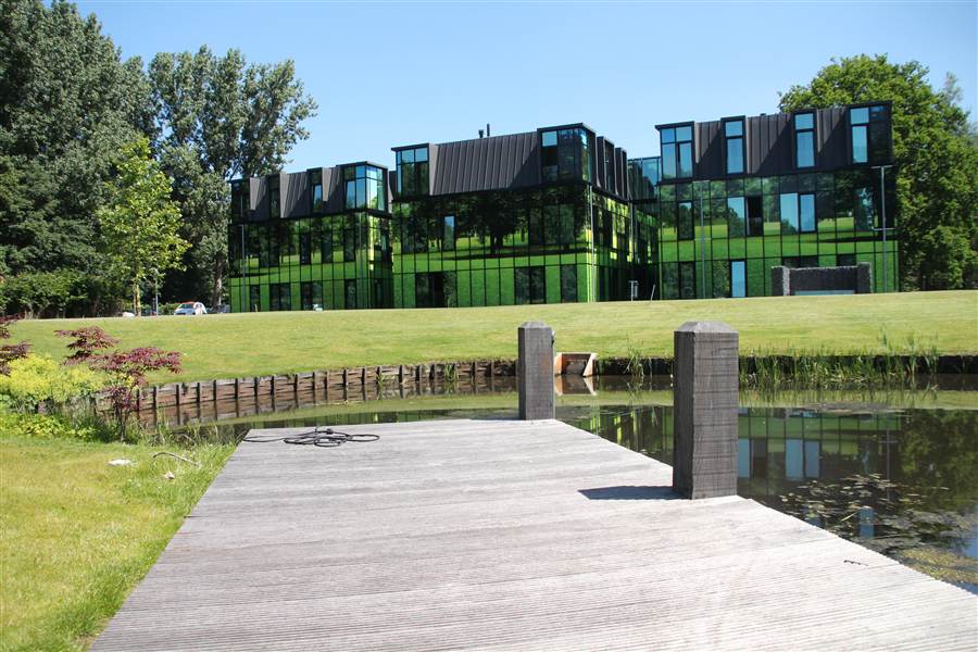 Woongebouw van Welcome Housing met tuin en water